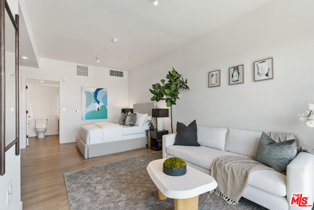 a living room with furniture and wooden floor