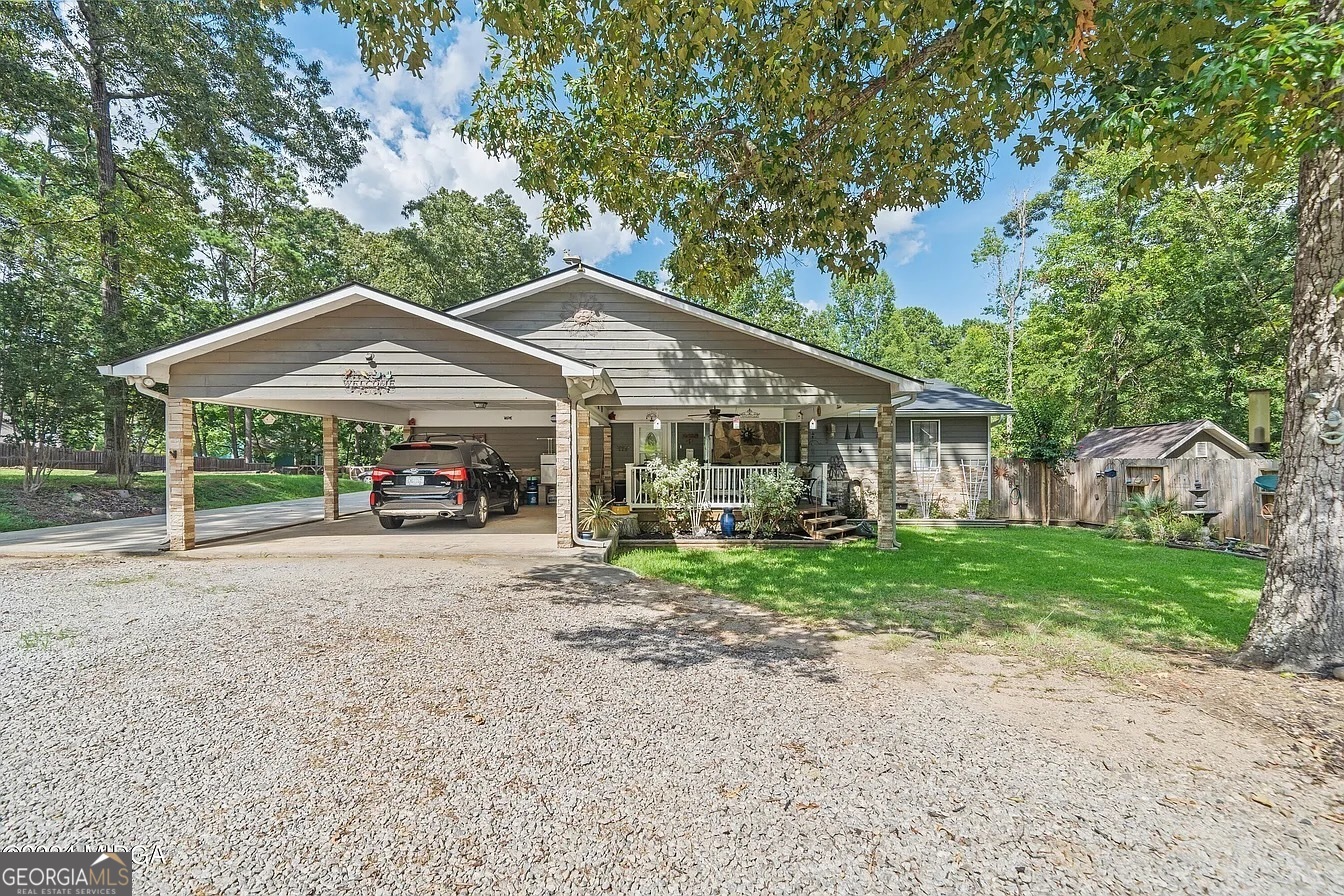 a view of a house with a yard and large trees