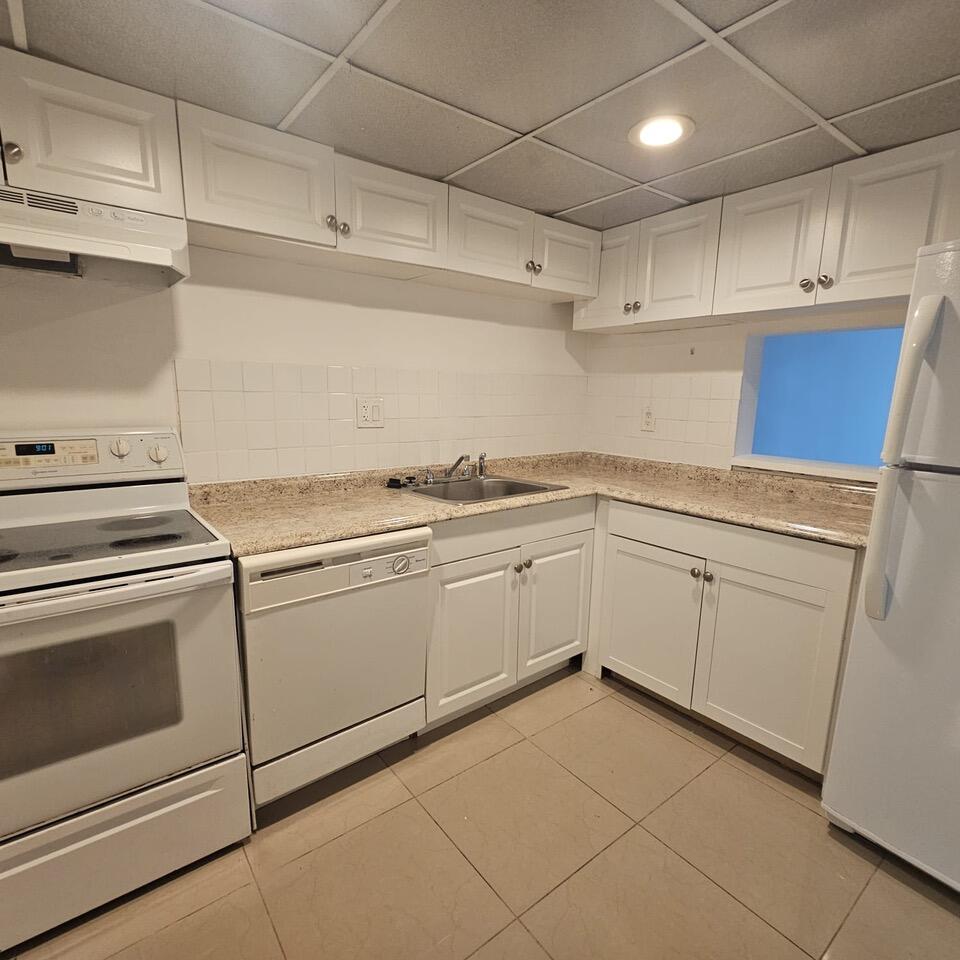 a kitchen with cabinets and white appliances