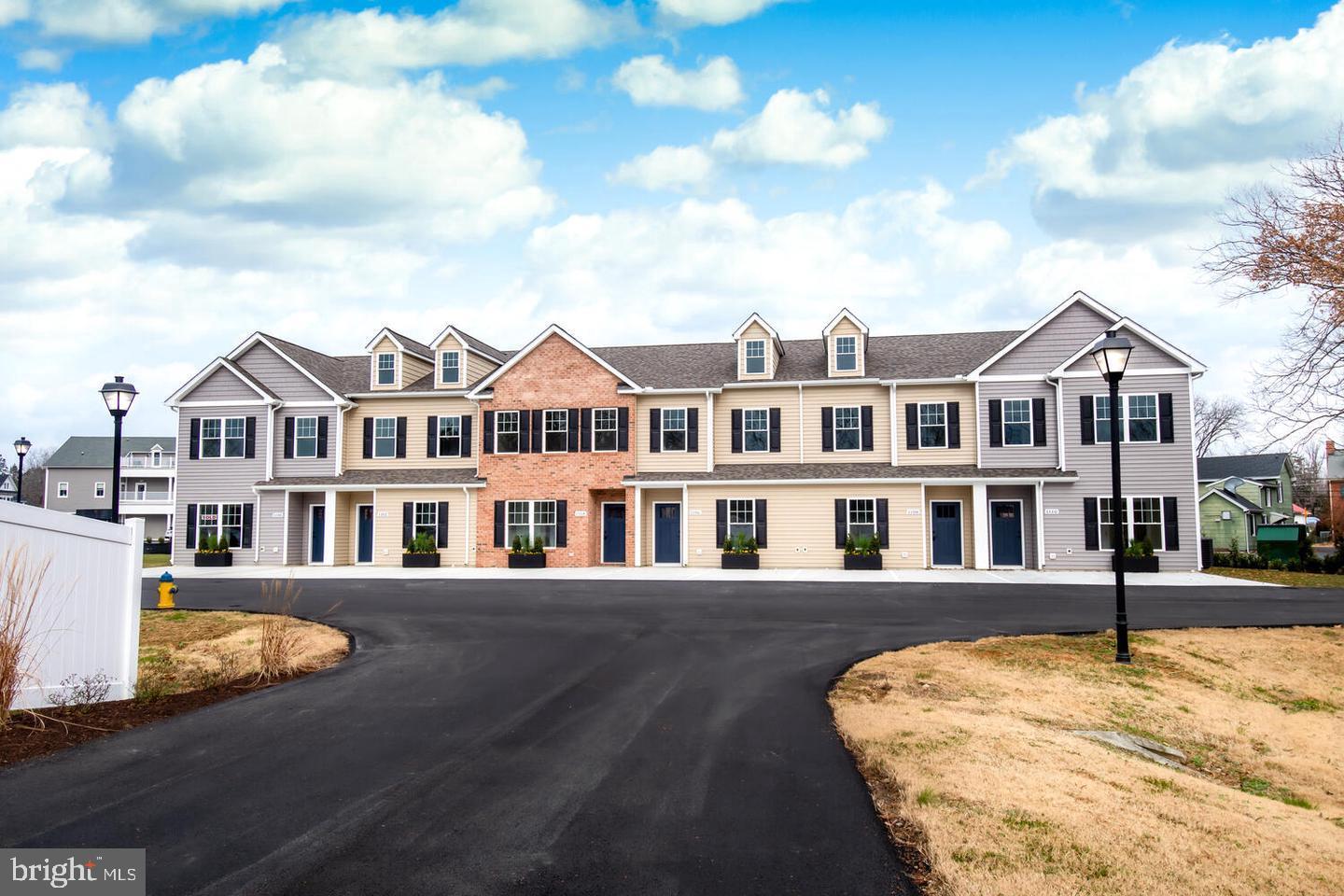 a view of a large white building next to a road