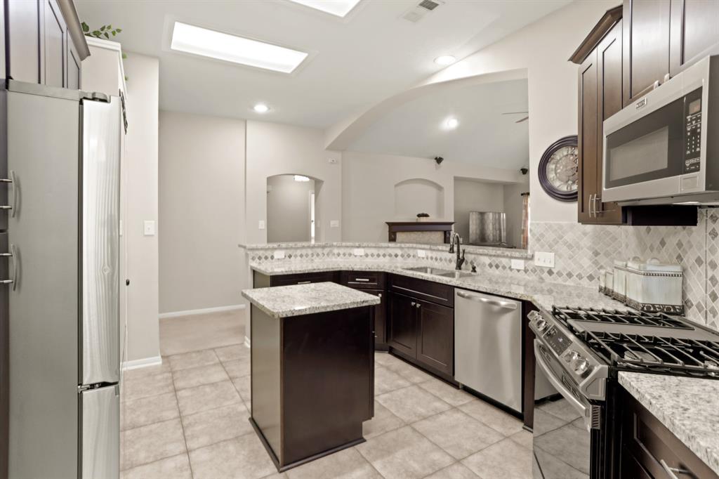 a kitchen with stainless steel appliances granite countertop a sink and a stove