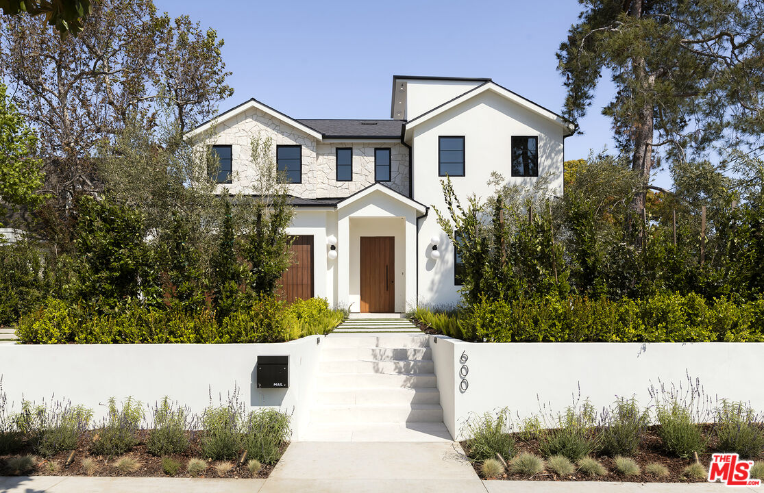 a front view of a house with a yard and trees