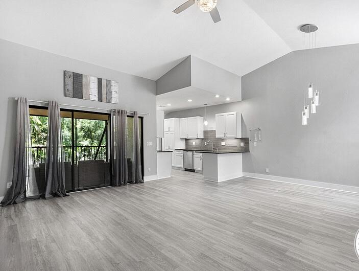 a view of kitchen with kitchen island wooden floor center island and stainless steel appliances