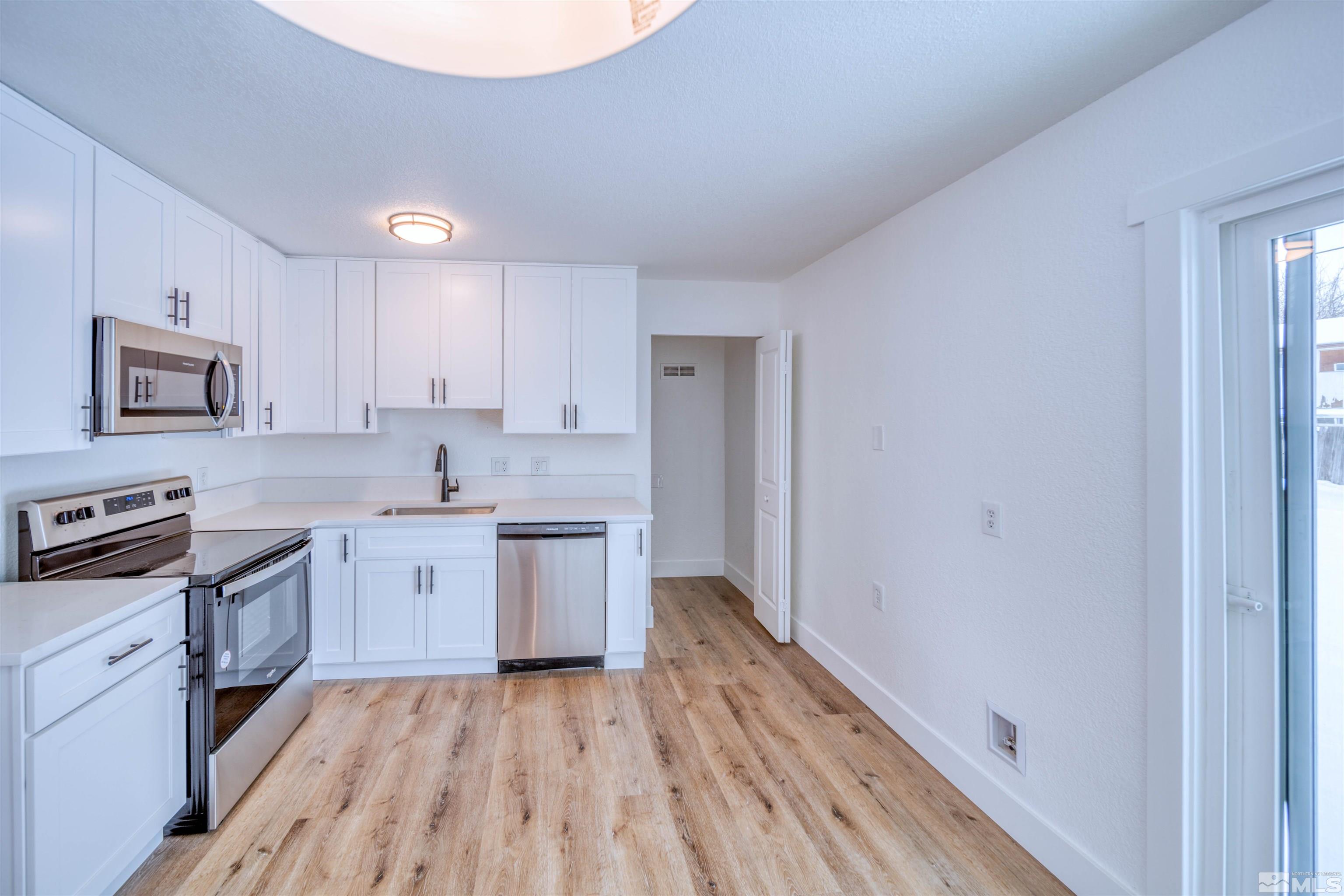 a kitchen with granite countertop a sink stove and refrigerator