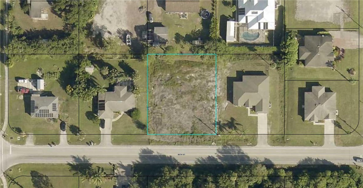 an aerial view of residential houses with outdoor space and parking