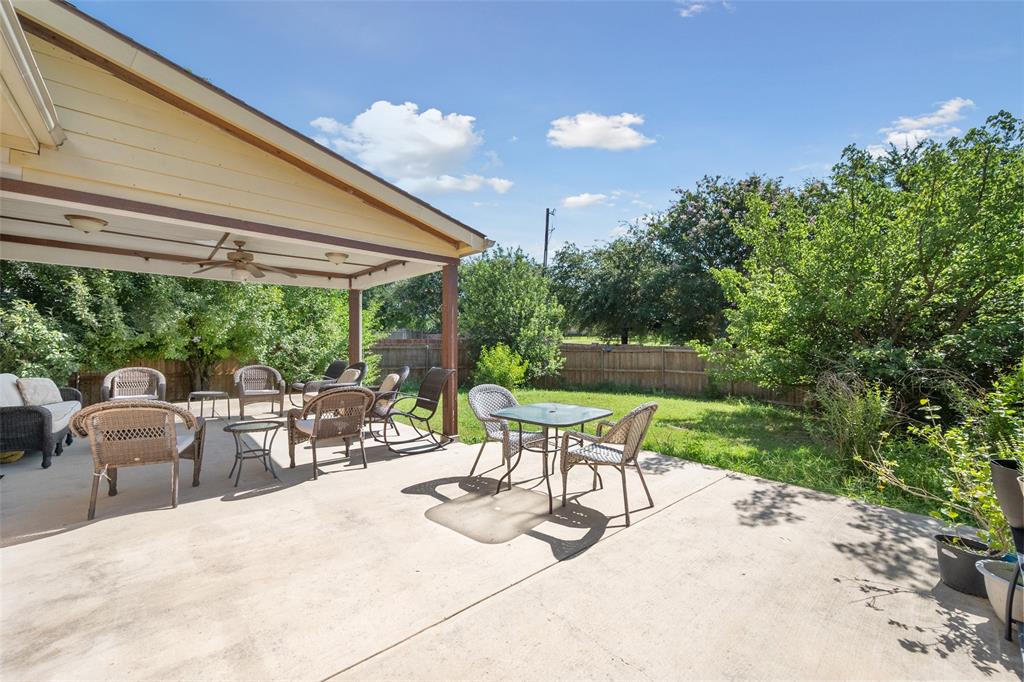 a view of patio with table and chairs under an umbrella