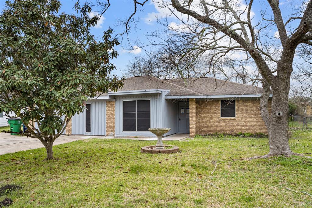 a front view of house with yard and trees in the background