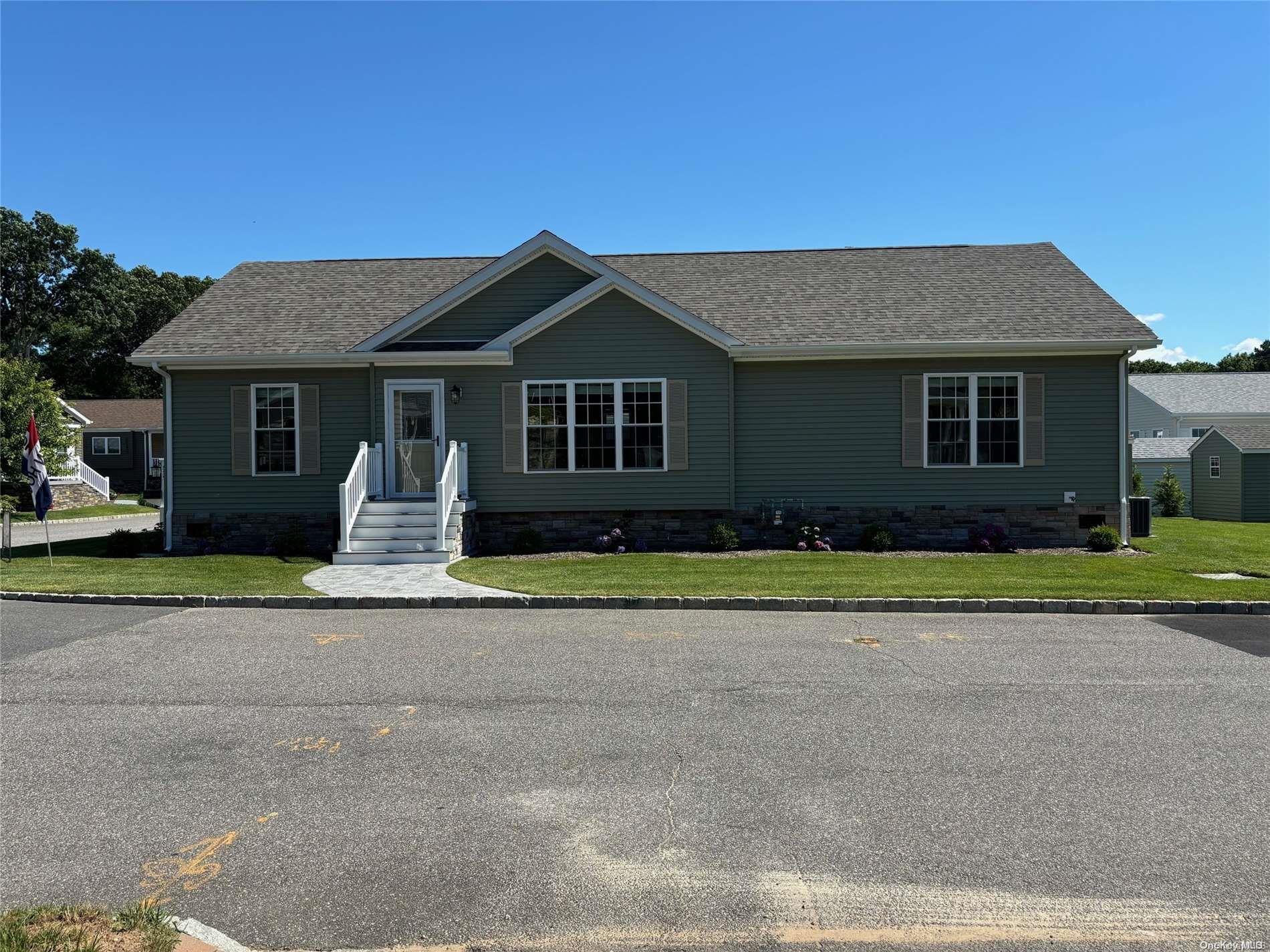 a front view of a house with a yard and trees