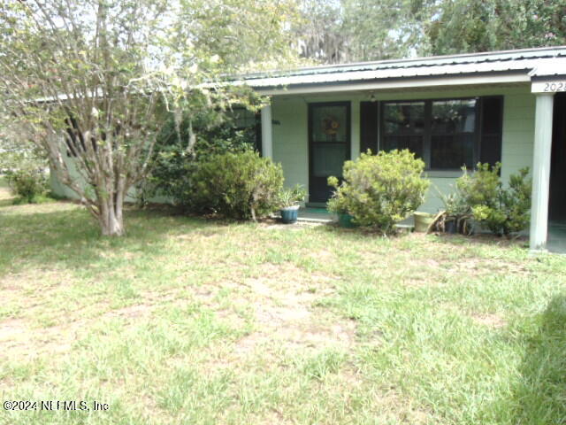 a view of a house with backyard and porch