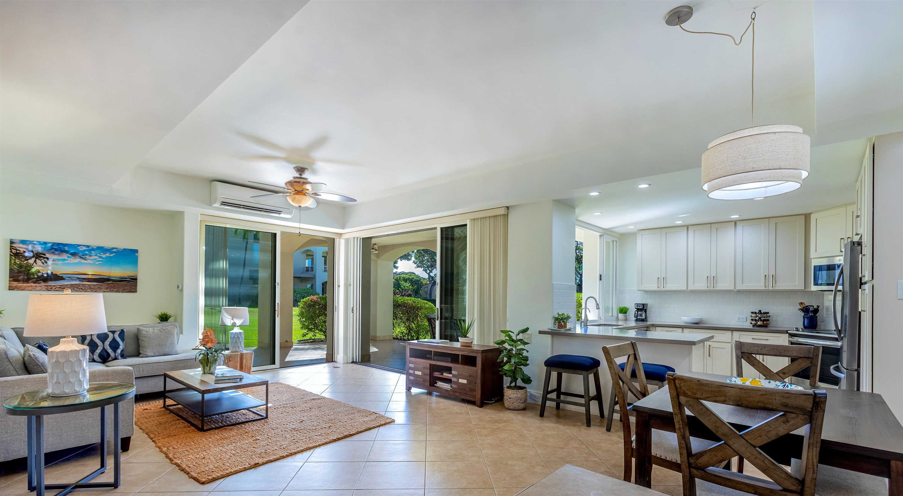 a living room with furniture kitchen view and a large window