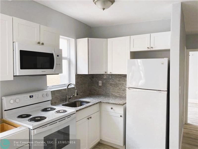 a kitchen with a refrigerator and a stove