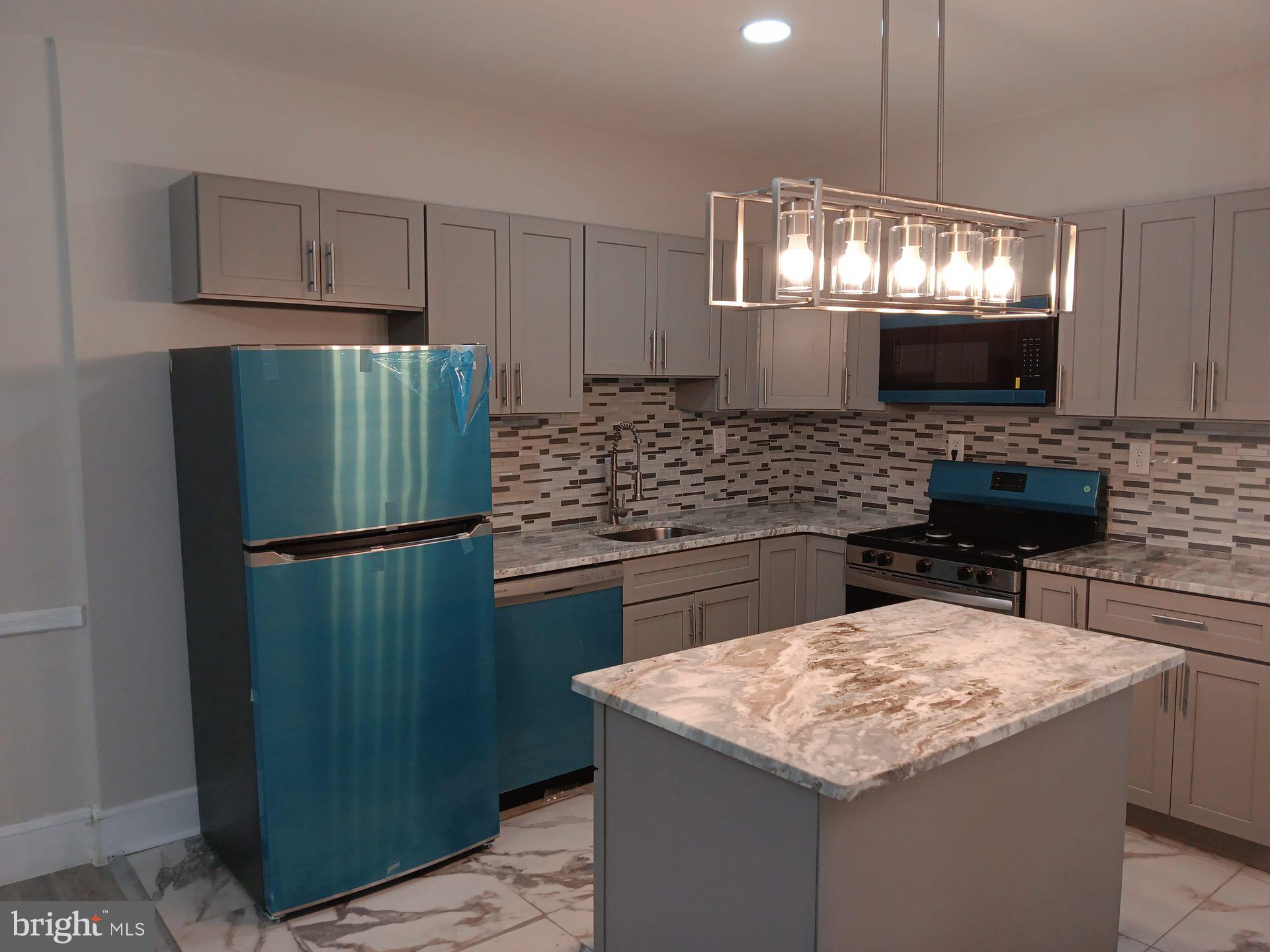 a kitchen with stainless steel appliances granite countertop a sink refrigerator and microwave