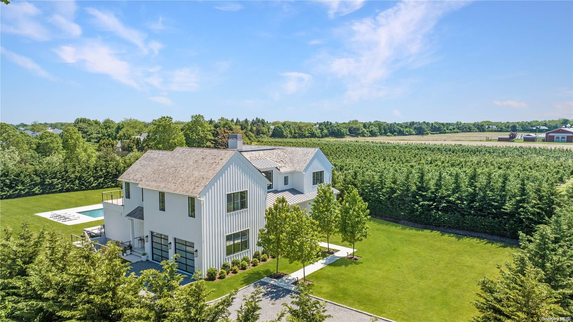 an aerial view of a house with a garden and lake view