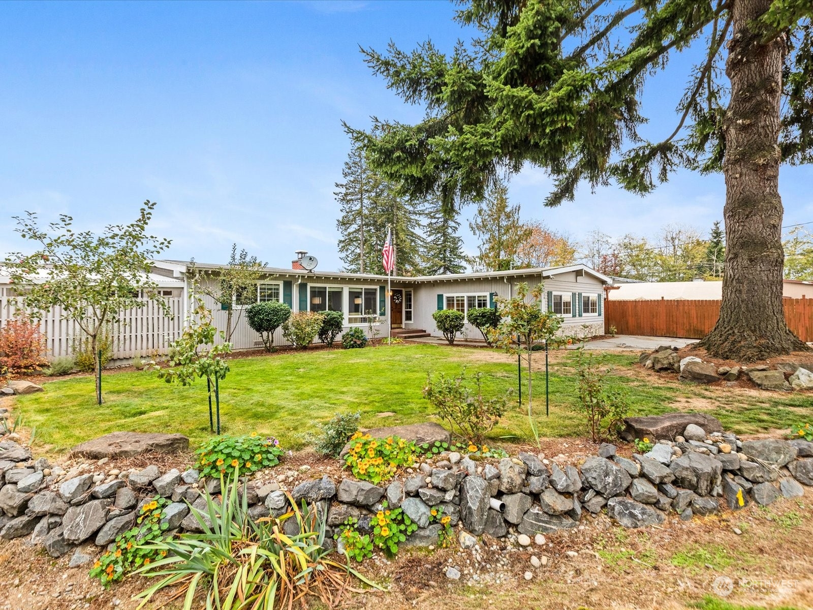 a view of house with a big yard and potted plants