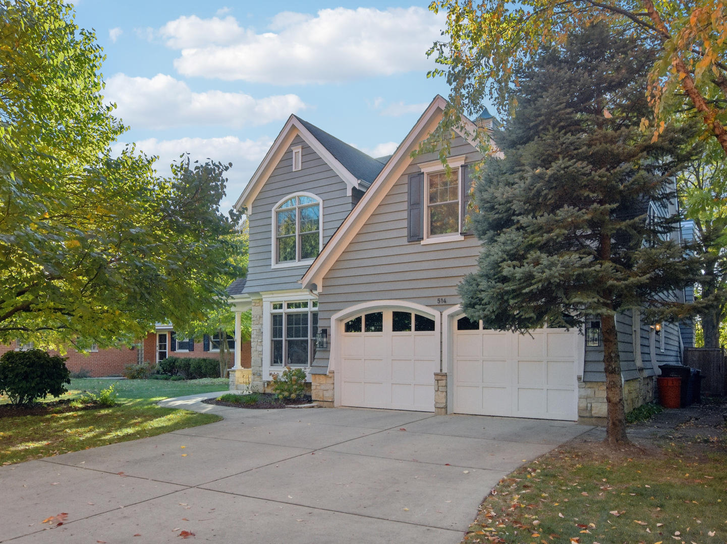 a view of a house with a yard and large trees