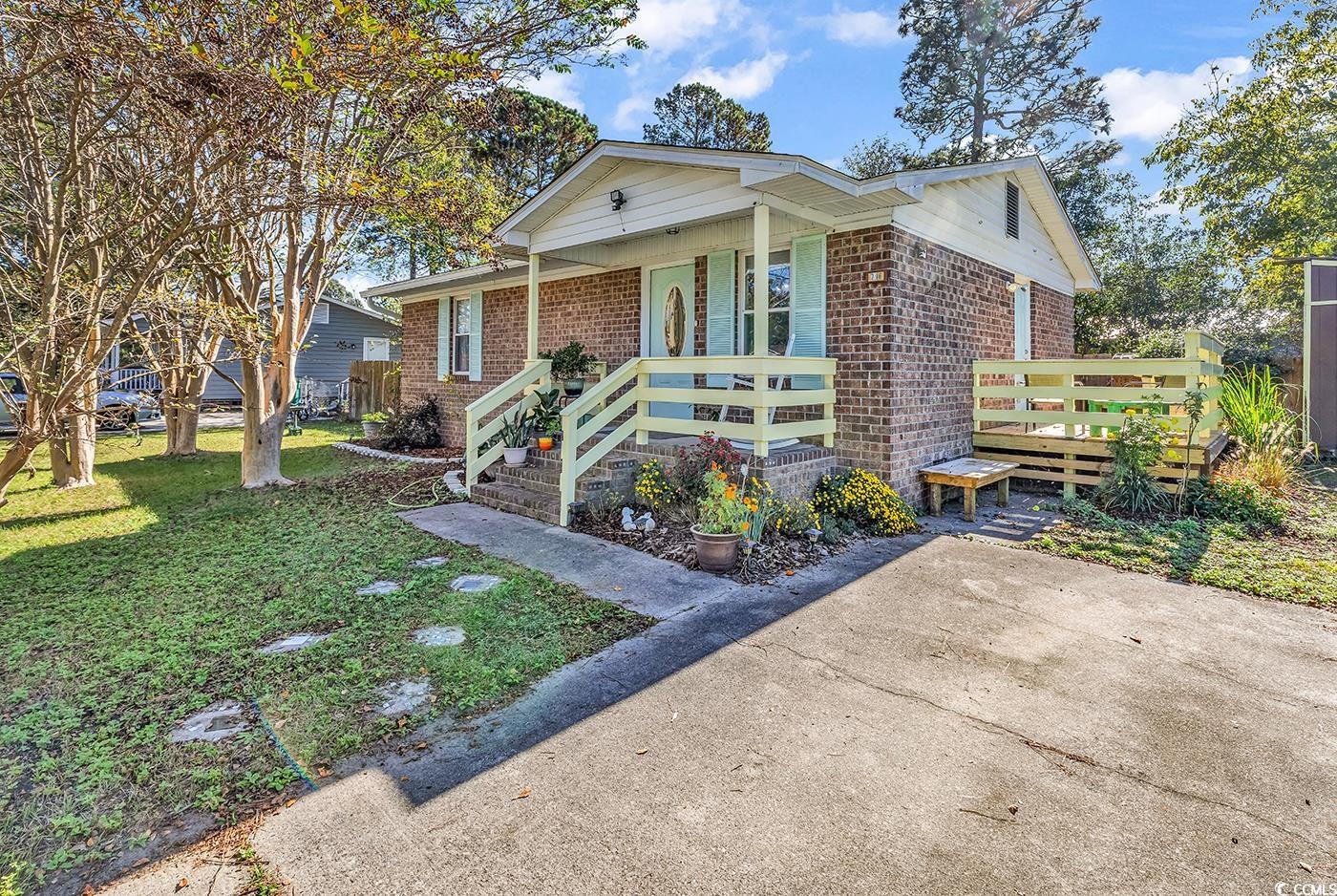 View of front of house with a porch and a front la