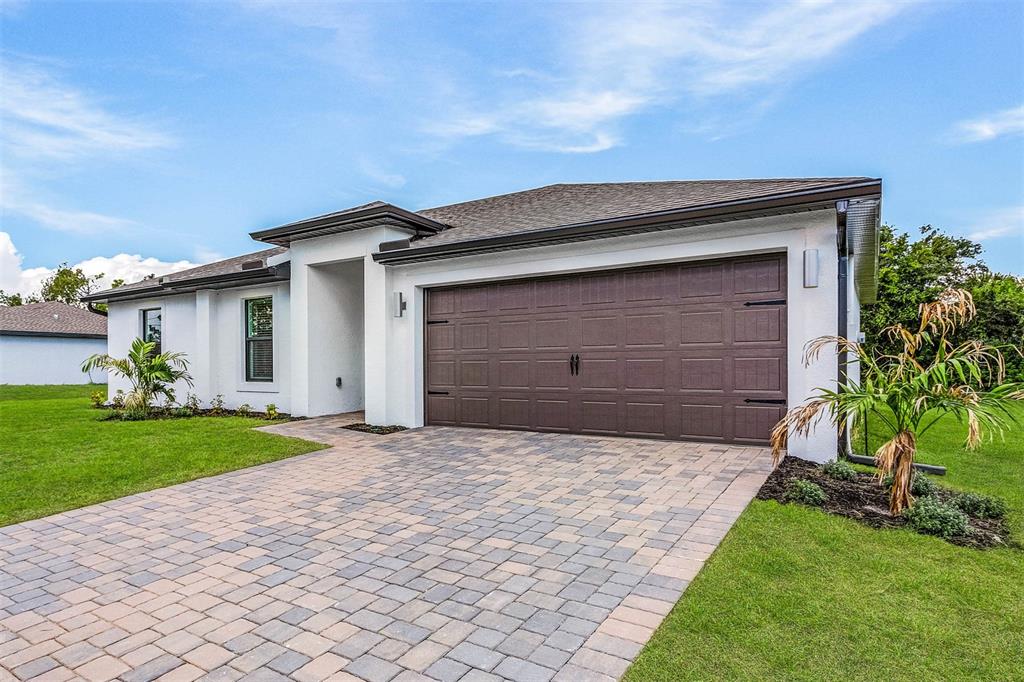 a front view of a house with a yard and garage