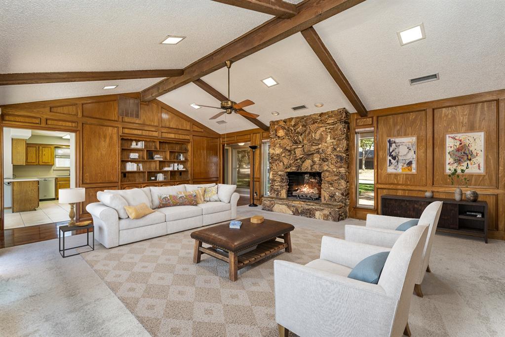 a living room with furniture a large window and a fireplace