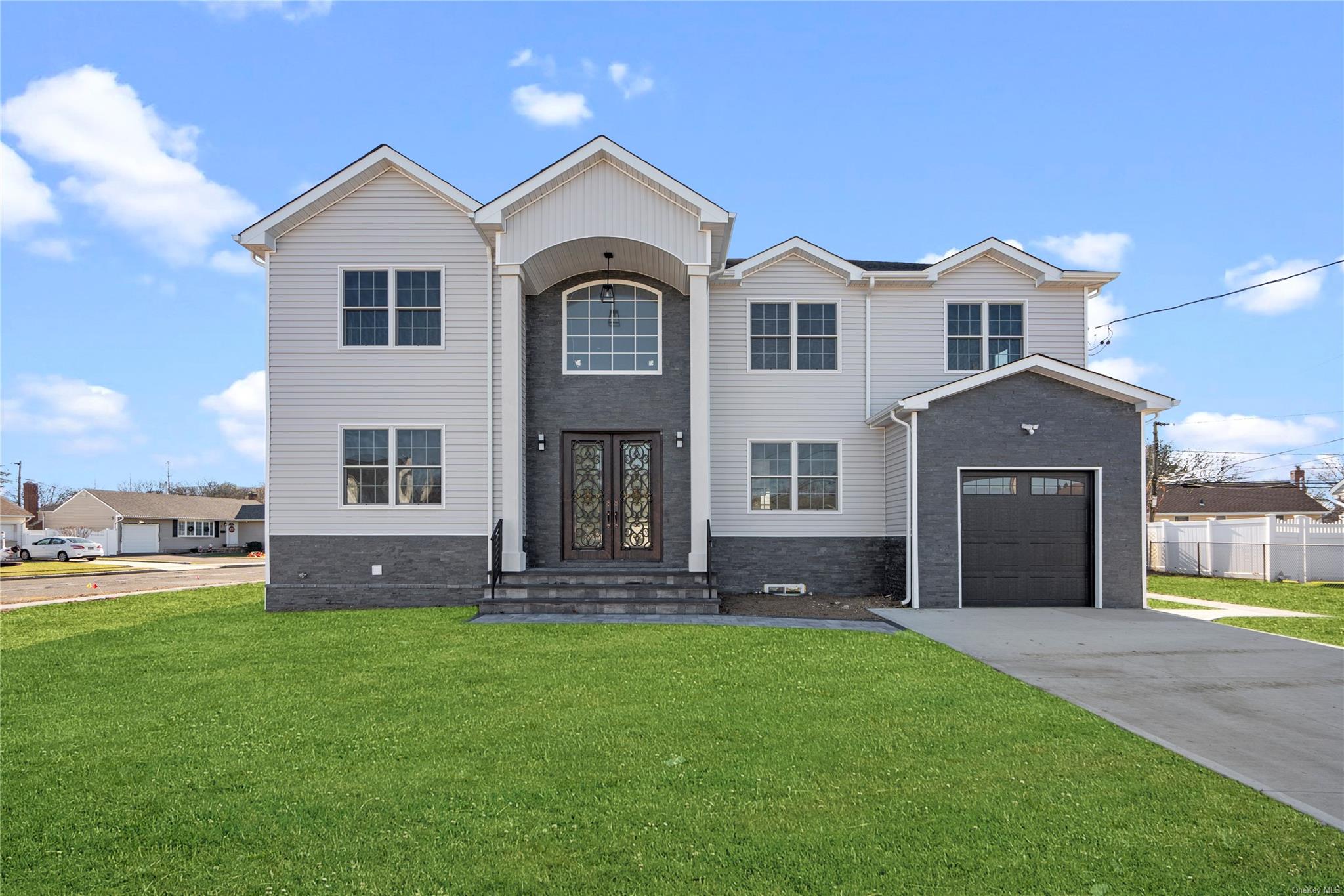 View of front of property featuring french doors, a garage, and a front lawn