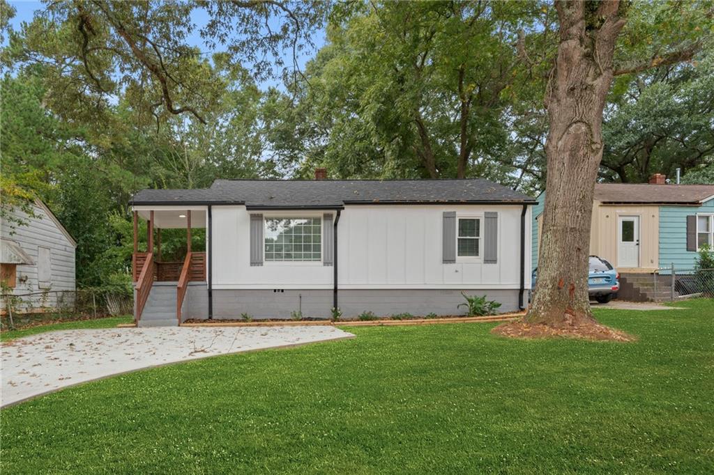 a view of a house with a backyard and a tree