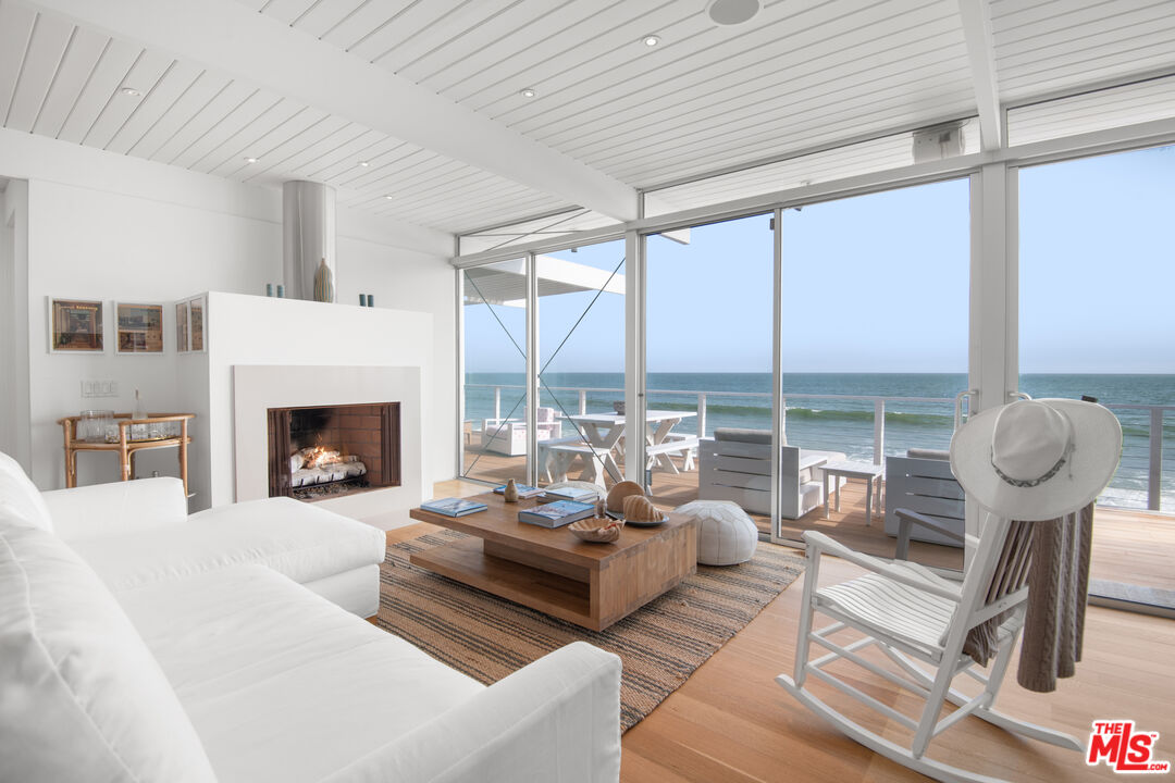 a living room with furniture large windows and a fireplace