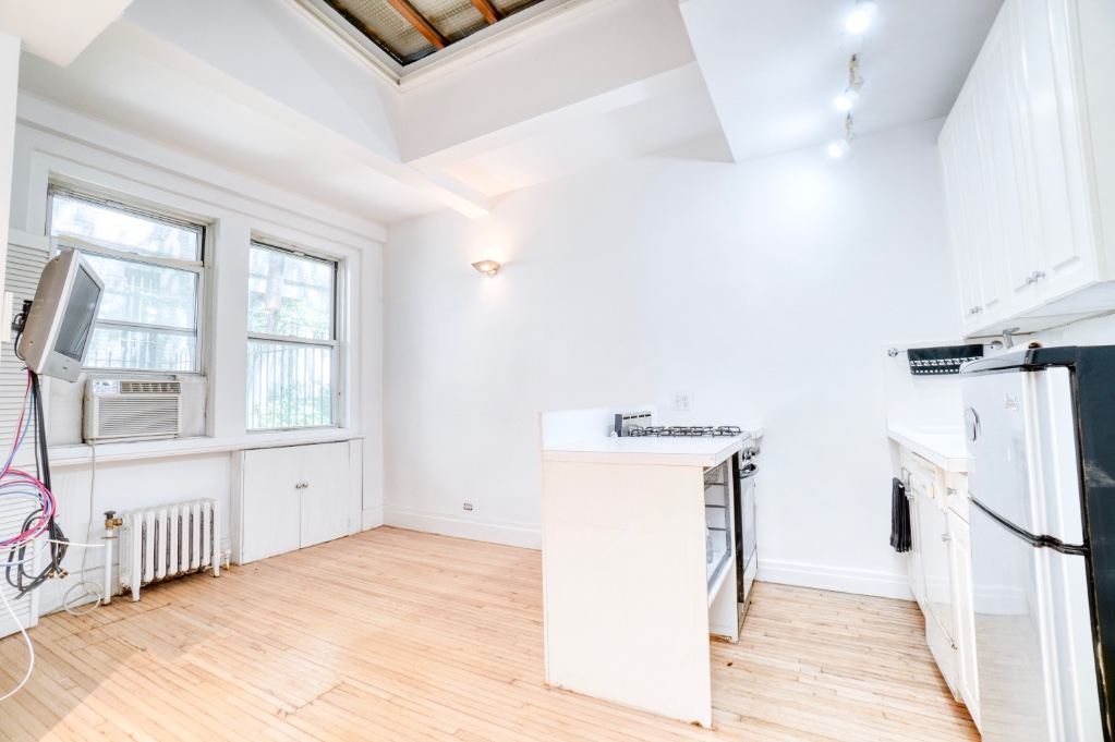 a view of a kitchen with a sink and dishwasher a refrigerator with wooden floor