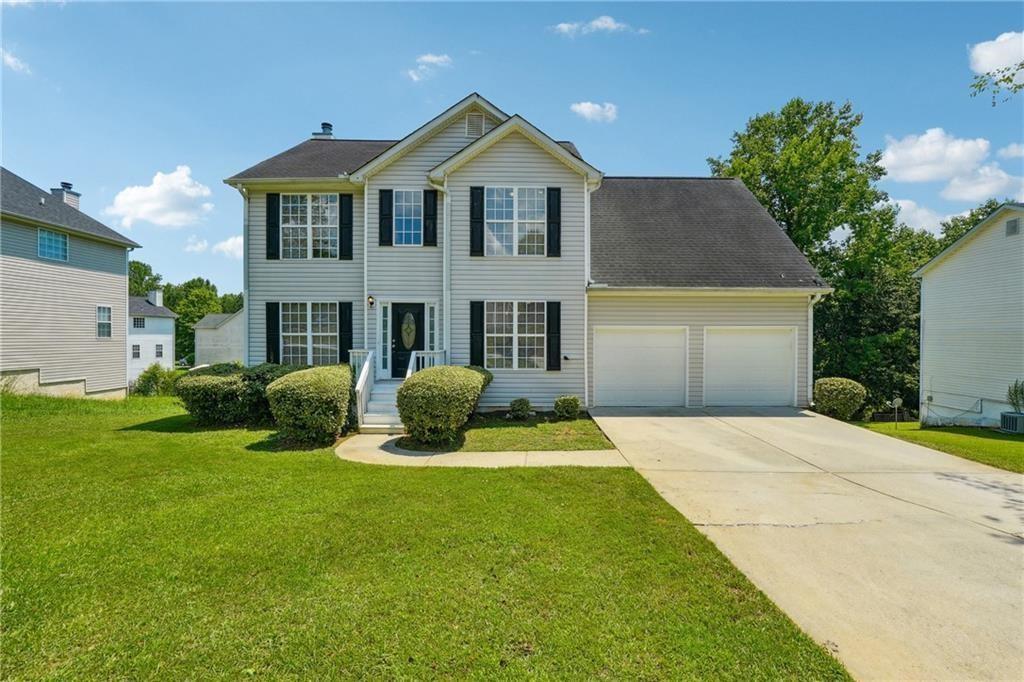 a front view of a house with a yard and garage