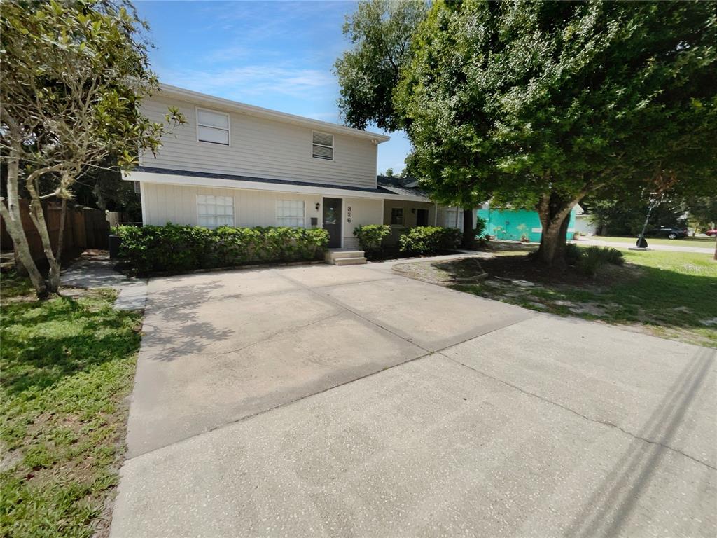 a front view of a house with yard and trees