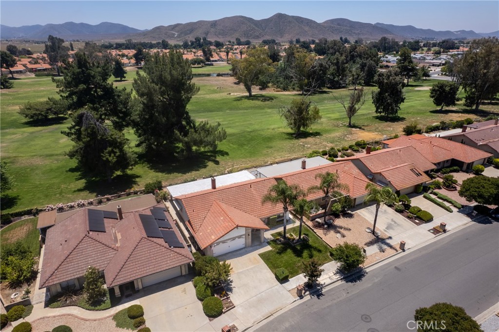 an aerial view of a house with garden space and mountain view in back