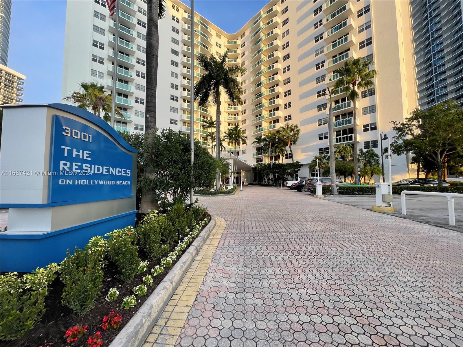 a street view with tall buildings and a street sign on a sidewalk