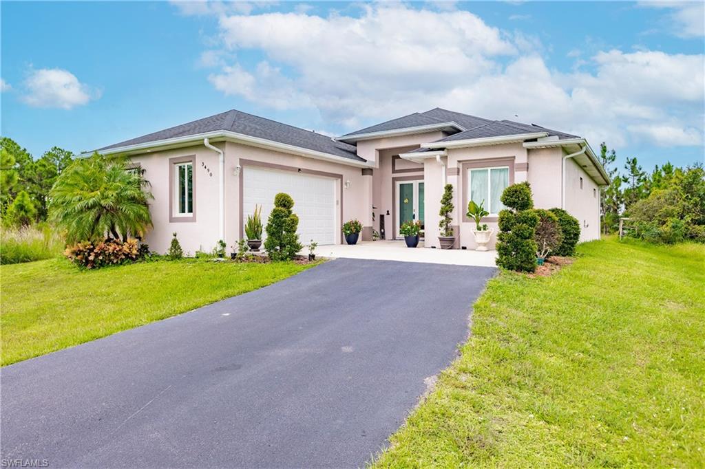 View of front of house with a garage and a front lawn