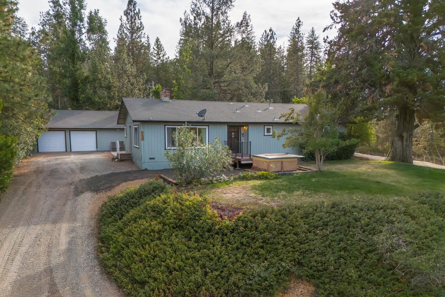 a front view of a house with a yard and trees