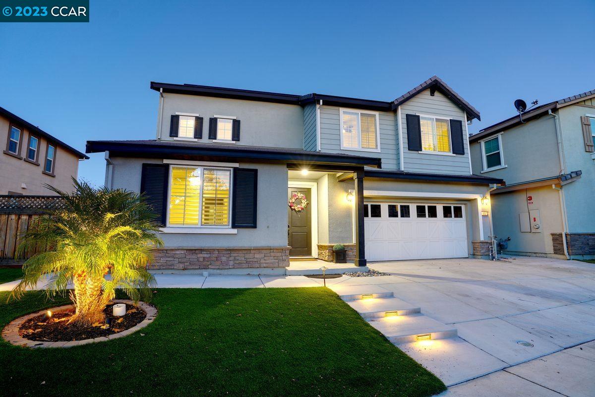 a front view of a house with a yard and fountain