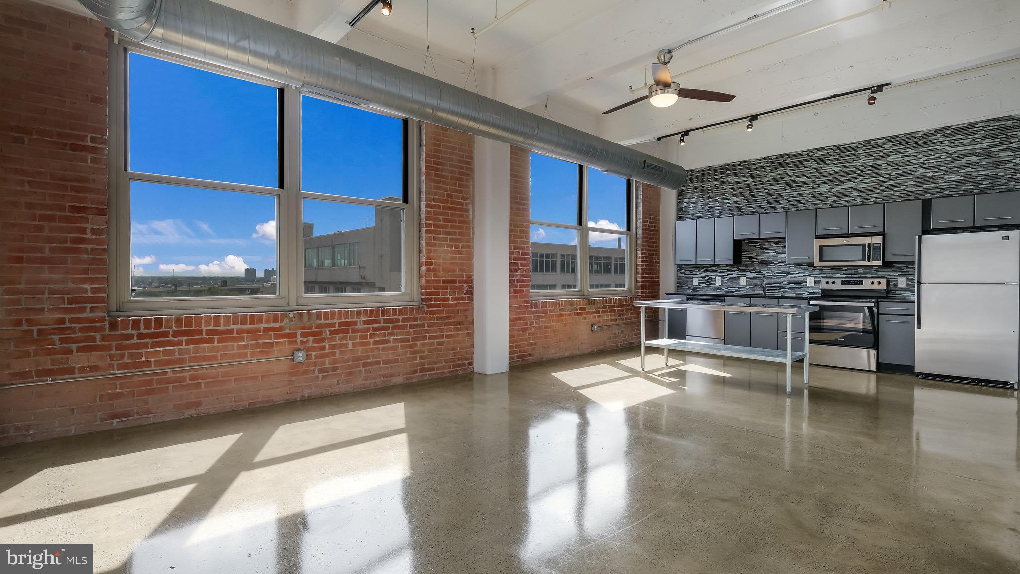 a kitchen with stainless steel appliances kitchen island granite countertop a refrigerator and a stove top oven