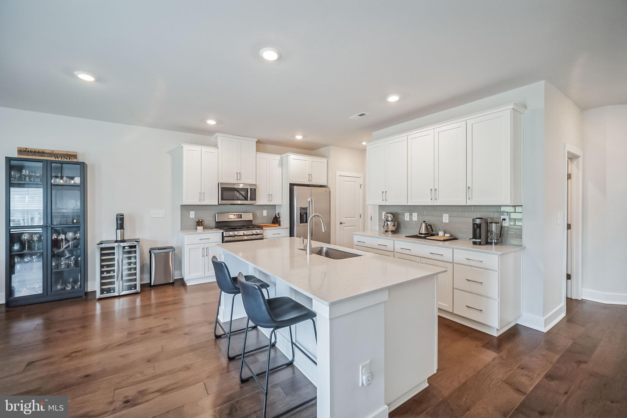 a kitchen with white cabinets stainless steel appliances and a center island