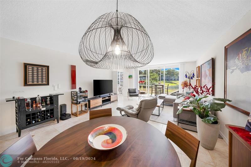 a living room with furniture a chandelier and a flat screen tv