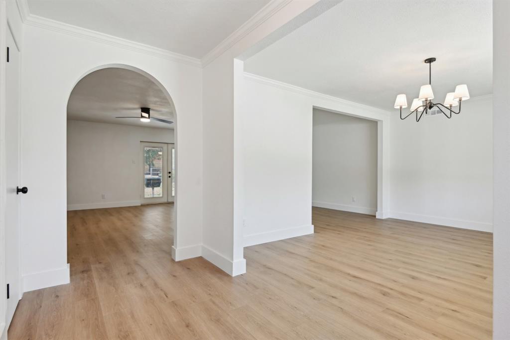 an empty room with wooden floor and mirror