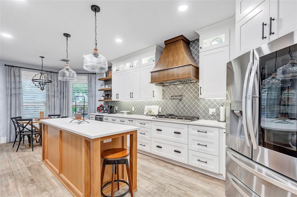 a kitchen that has a lot of cabinets and wooden floor