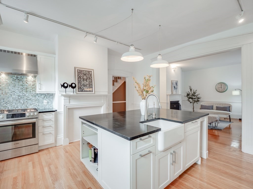 a kitchen with stainless steel appliances granite countertop a sink stove and refrigerator