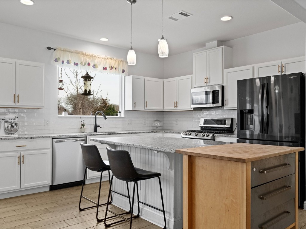 a kitchen with appliances a sink cabinets and wooden floor