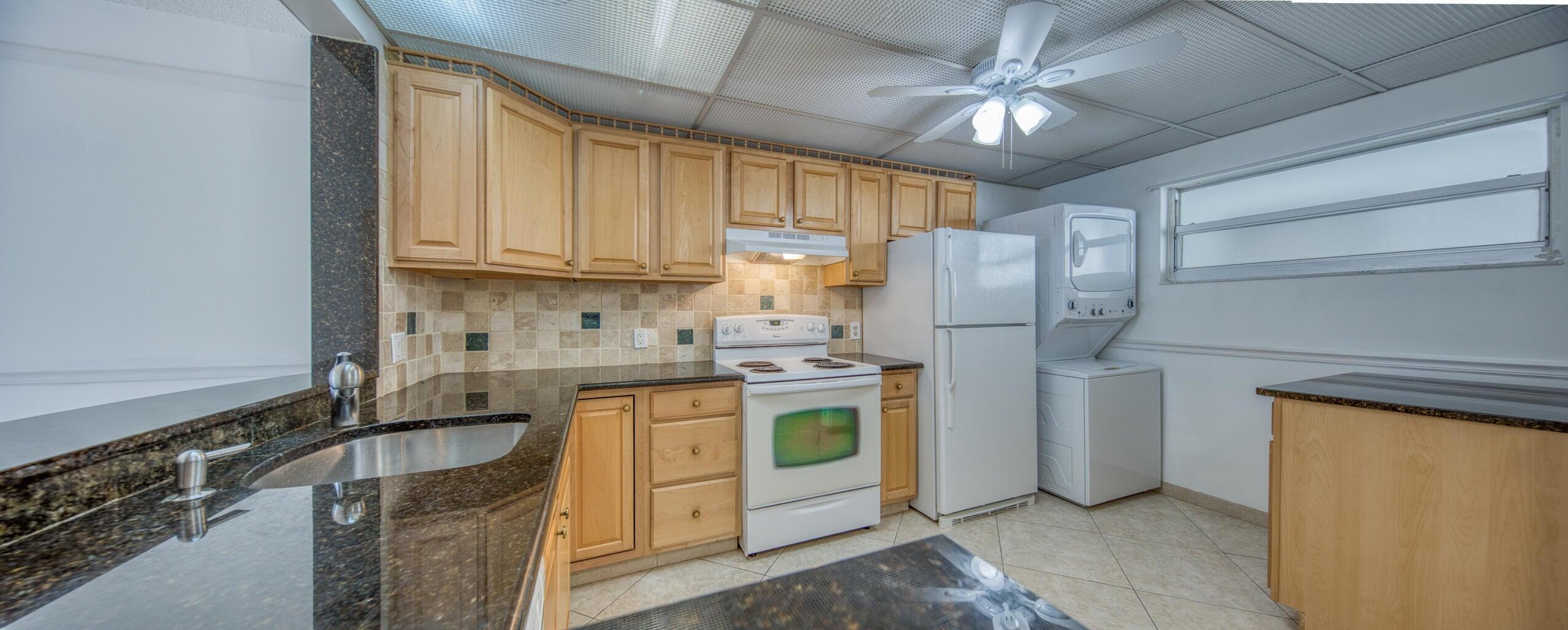 a kitchen with stainless steel appliances granite countertop a stove a refrigerator and a sink with cabinets