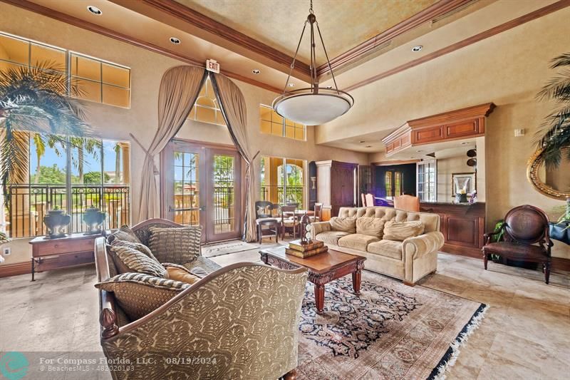 a living room with furniture a chandelier and a large window