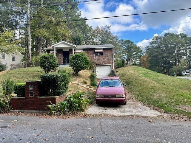 a front view of a house with a garden and parking