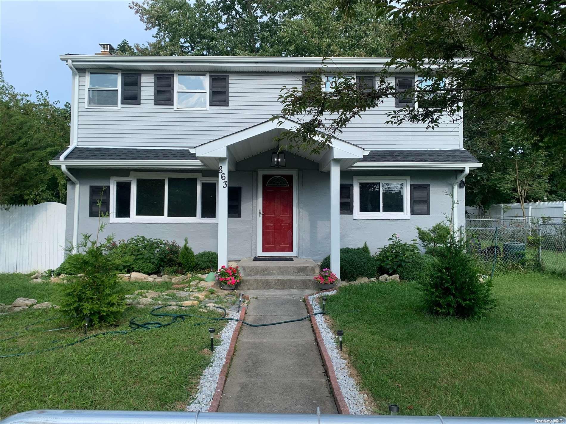 a front view of a house with a garden and plants