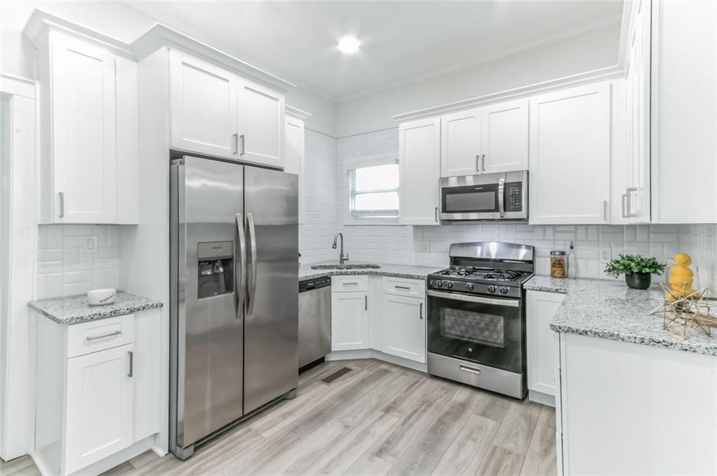 a kitchen with stainless steel appliances granite countertop a refrigerator stove and sink