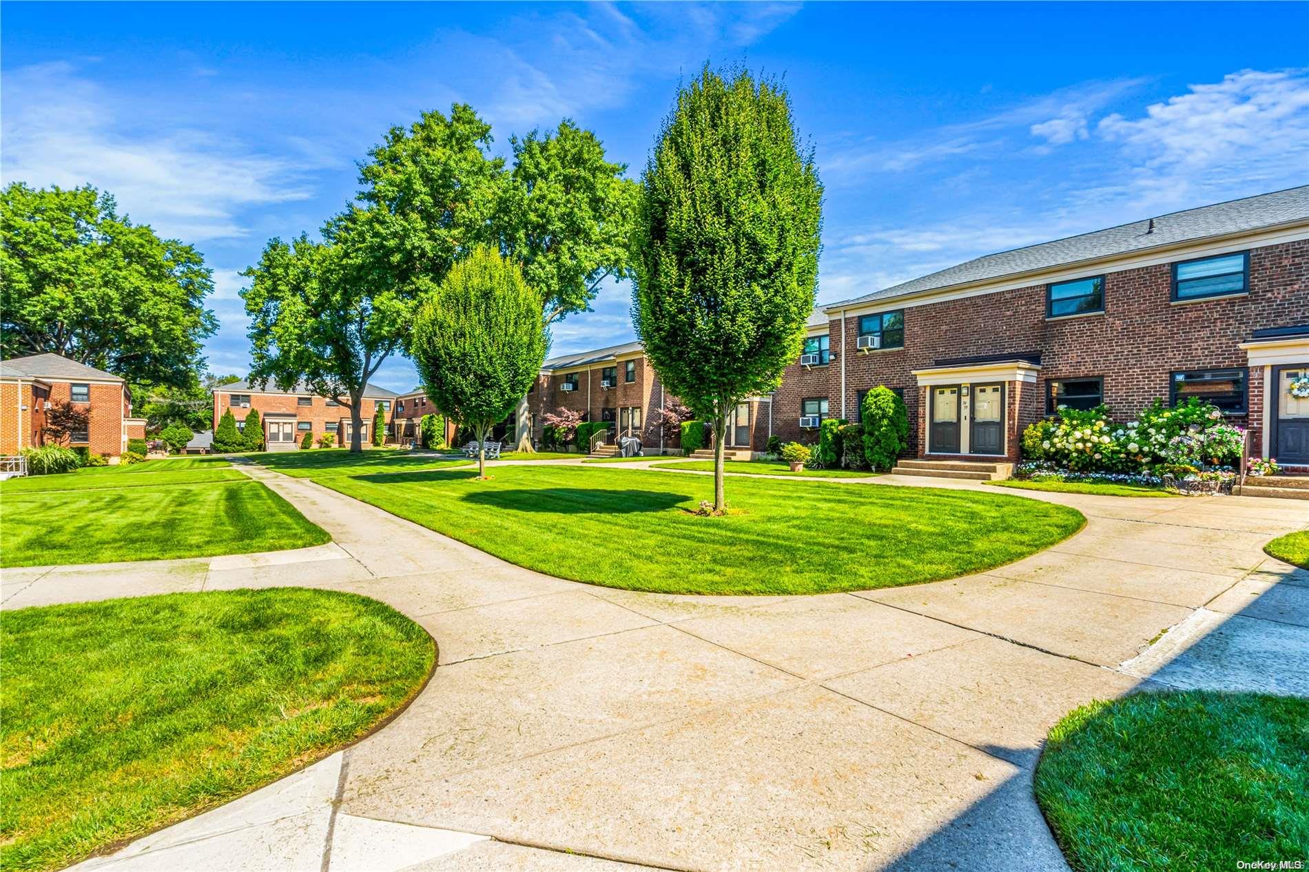 a view of a big building with a big yard and plants