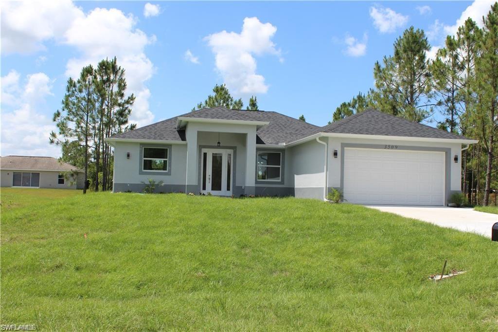 View of front of property featuring a front lawn and a garage