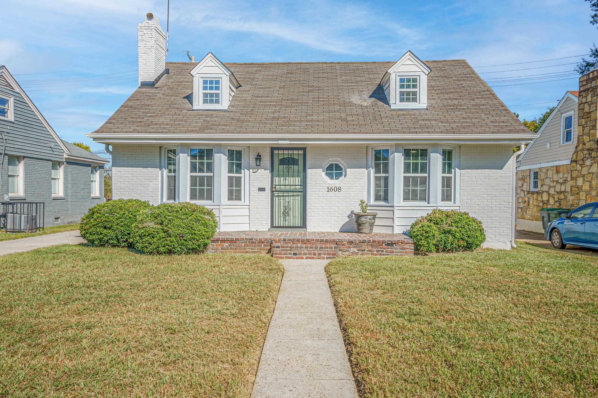 View of front facade with cooling unit and a front lawn