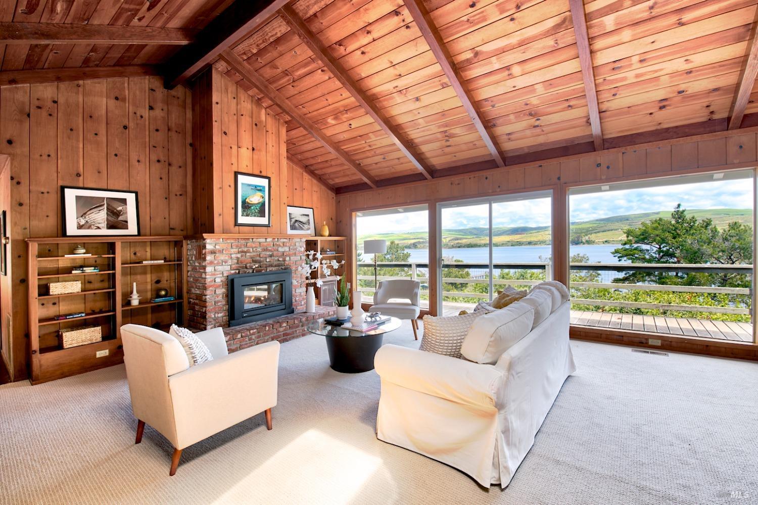 a living room with furniture a fireplace and a large window