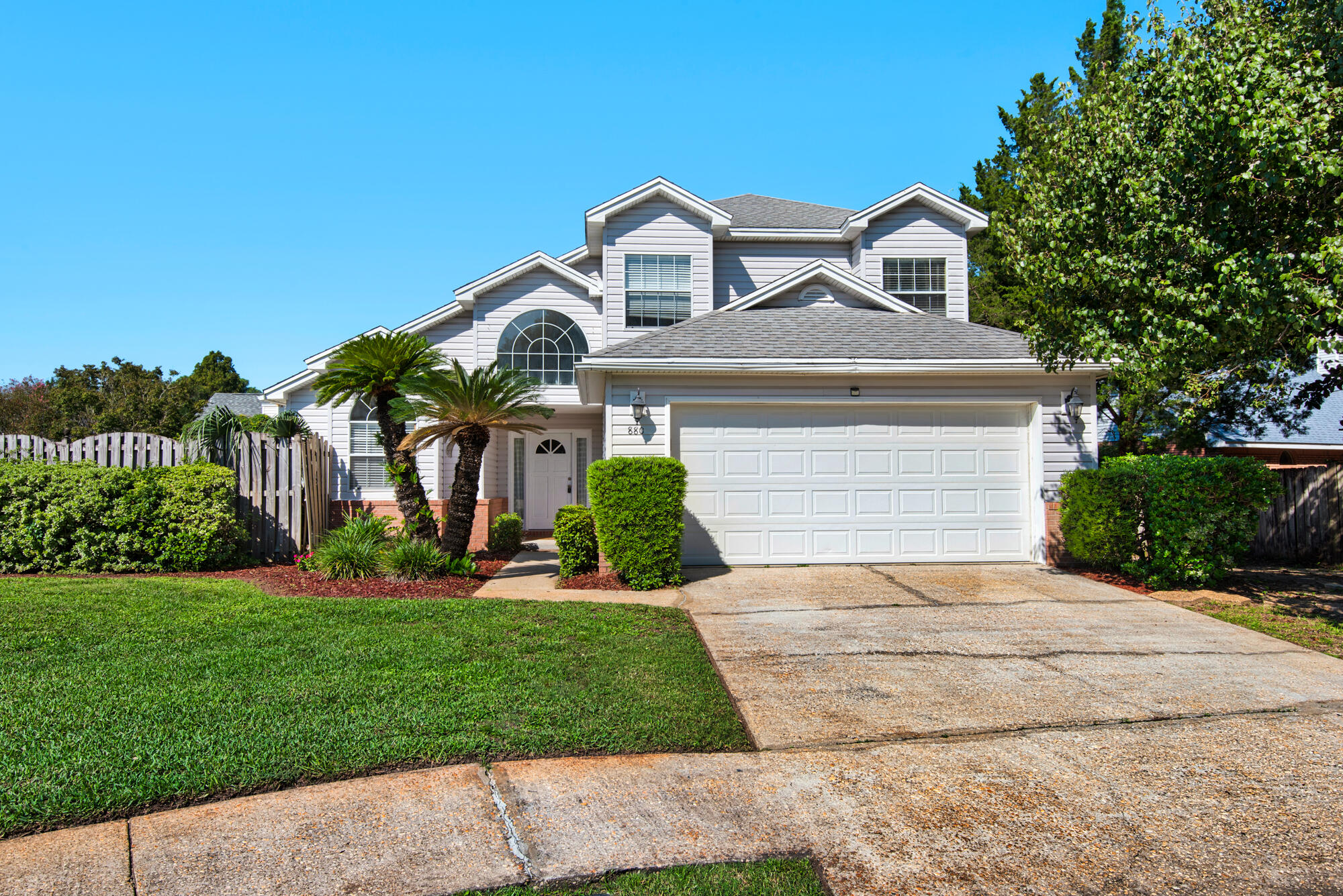 a front view of a house with a yard and potted plants